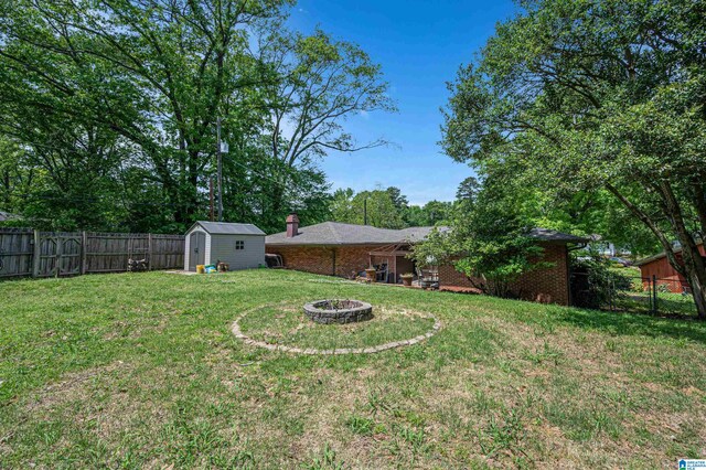 view of yard featuring a storage unit and an outdoor fire pit