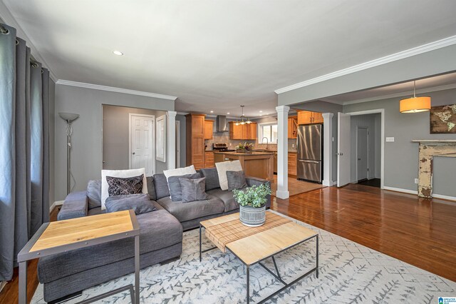 living room with light wood-type flooring and ornamental molding