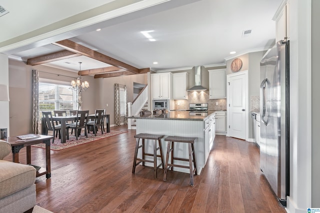 kitchen with wall chimney exhaust hood, stainless steel appliances, a kitchen island, dark hardwood / wood-style flooring, and white cabinets