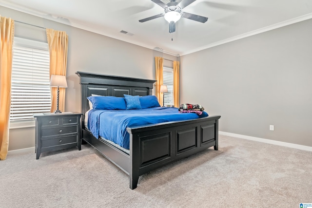 bedroom featuring multiple windows, ceiling fan, crown molding, and light colored carpet