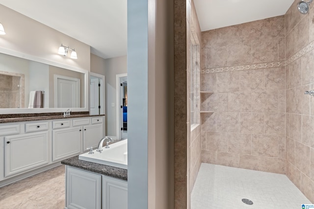 bathroom with vanity and tiled shower