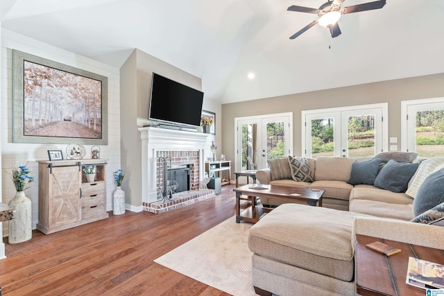 living room with vaulted ceiling, wood-type flooring, a wealth of natural light, and french doors