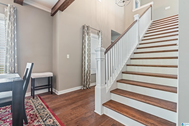 interior space featuring beam ceiling, a chandelier, ornamental molding, and hardwood / wood-style flooring