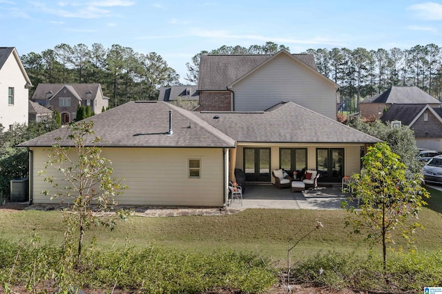 rear view of house featuring a patio, central AC, and a lawn