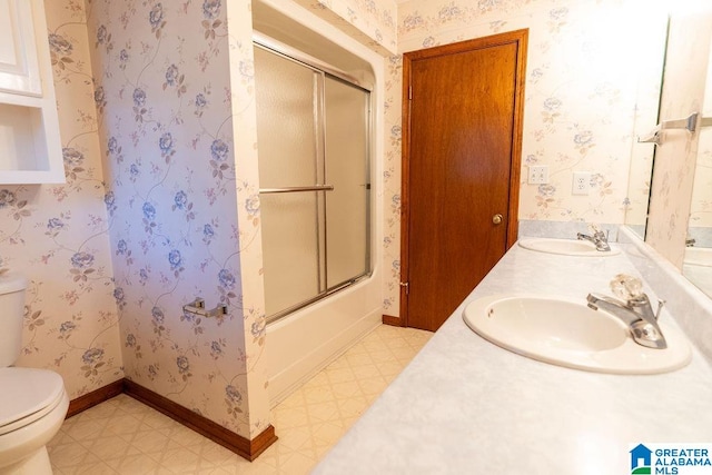 full bathroom featuring vanity, toilet, and bath / shower combo with glass door