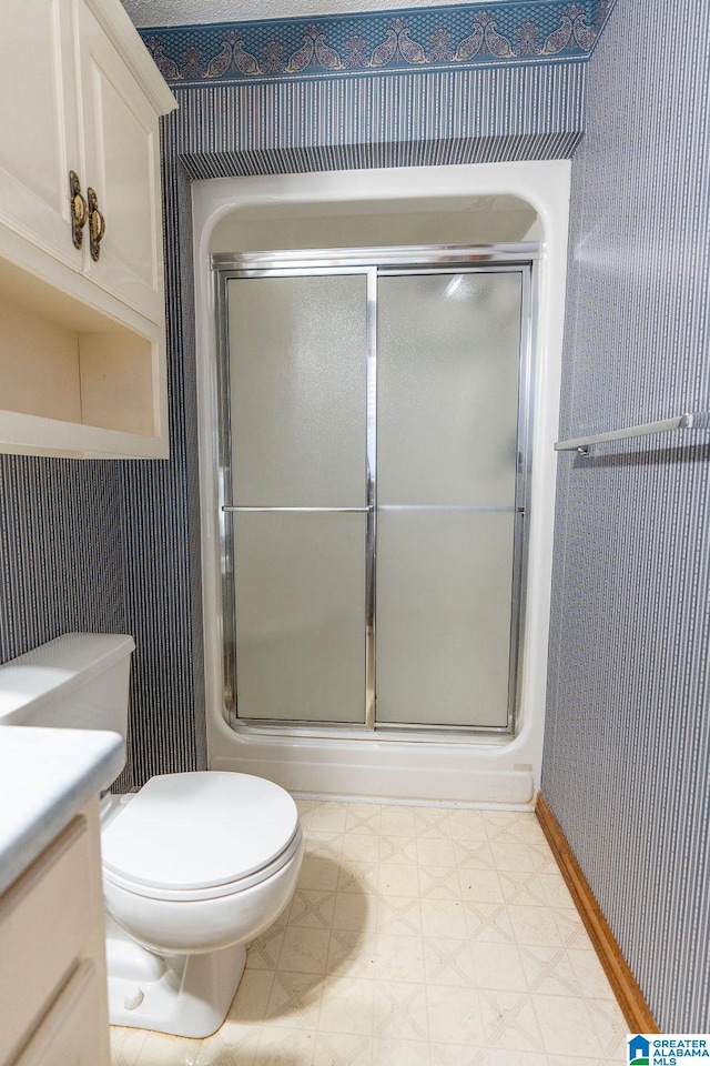 bathroom featuring vanity, toilet, and an enclosed shower