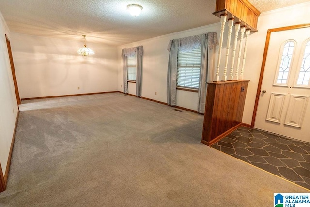 carpeted entryway with crown molding and a textured ceiling