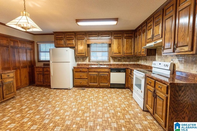 kitchen with pendant lighting, backsplash, white appliances, and sink