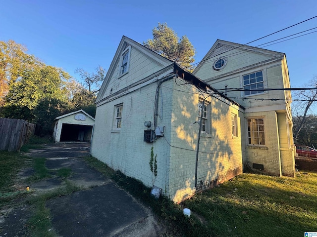 view of side of property with a garage, an outdoor structure, and a lawn