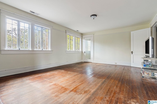 empty room featuring hardwood / wood-style flooring and a healthy amount of sunlight