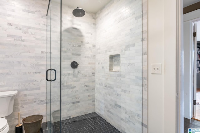 bathroom with hardwood / wood-style flooring, toilet, and an enclosed shower