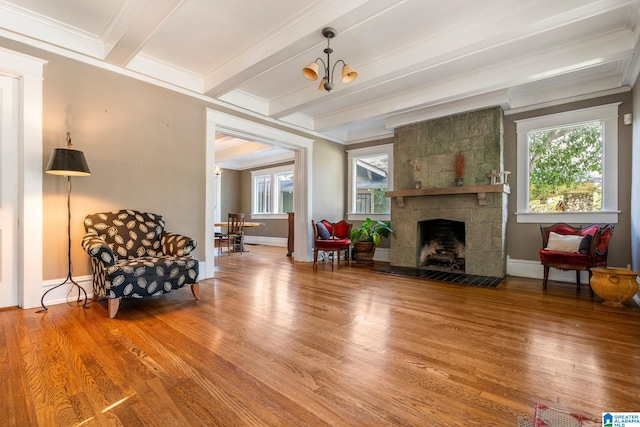 sitting room featuring hardwood / wood-style floors, a fireplace, a wealth of natural light, and beamed ceiling