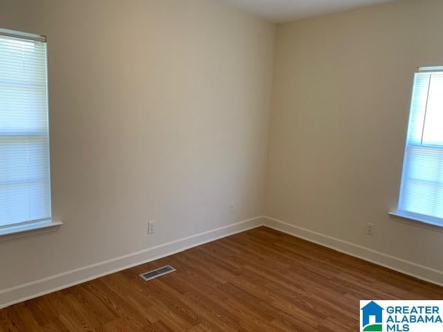 unfurnished room with dark hardwood / wood-style flooring