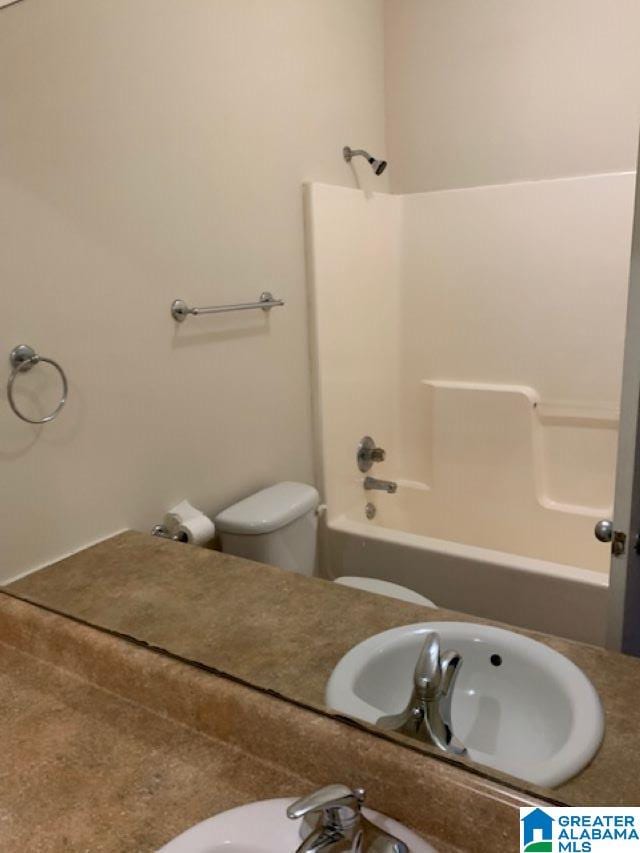 full bathroom with sink, bathtub / shower combination, and toilet