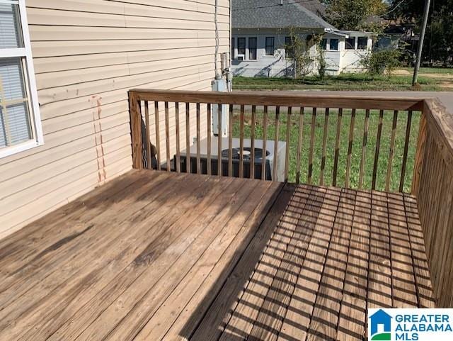 wooden deck featuring a lawn