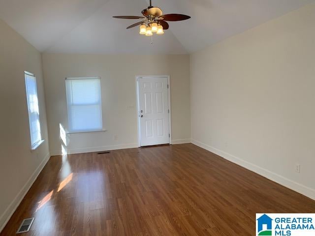 spare room with ceiling fan, dark hardwood / wood-style flooring, and vaulted ceiling