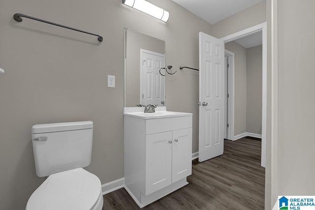 bathroom with hardwood / wood-style floors, vanity, and toilet