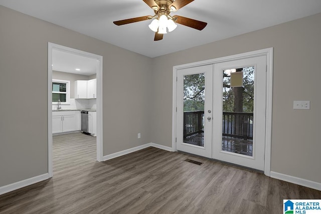 unfurnished room with french doors, sink, ceiling fan, and hardwood / wood-style floors