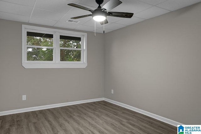 empty room with hardwood / wood-style floors, a paneled ceiling, and ceiling fan