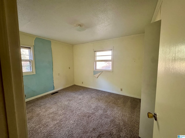 carpeted spare room with a textured ceiling