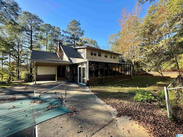 back of property featuring a sunroom and a patio area