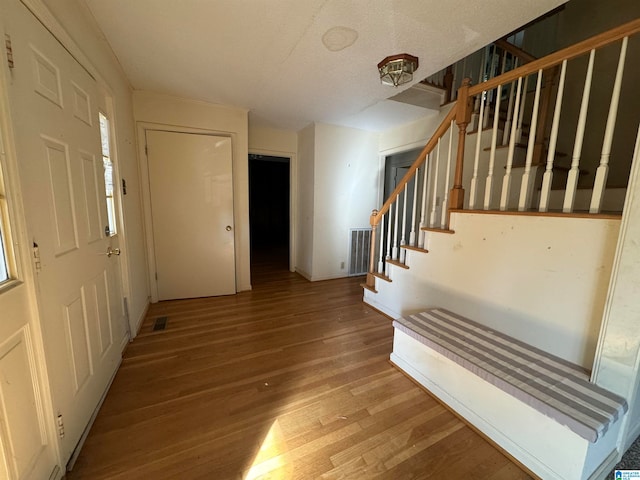 entrance foyer featuring wood-type flooring and a textured ceiling