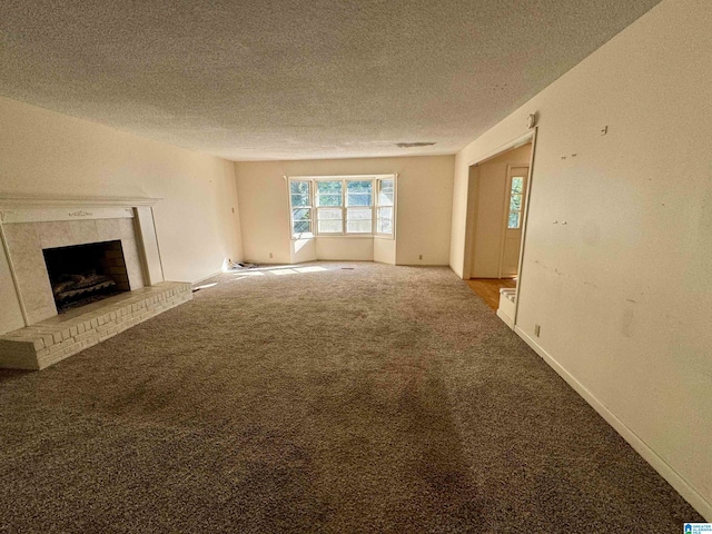 unfurnished living room featuring carpet, a textured ceiling, and a fireplace