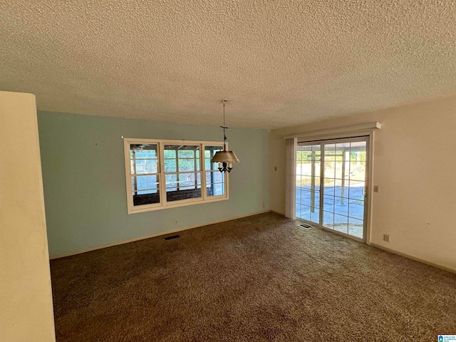 carpeted empty room featuring a textured ceiling