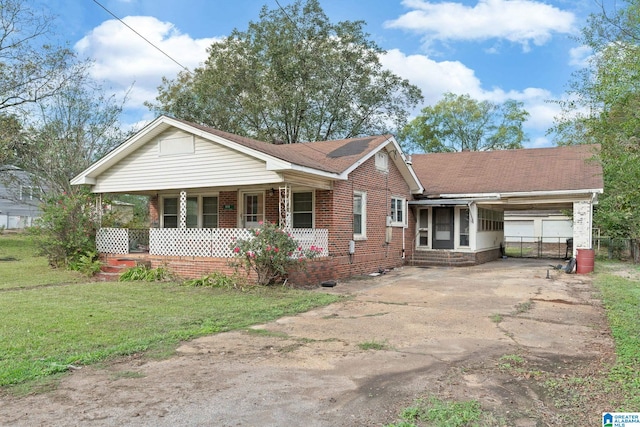 single story home featuring covered porch, a front yard, and a carport