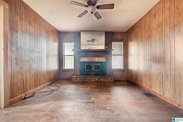 unfurnished living room featuring hardwood / wood-style floors and wood walls