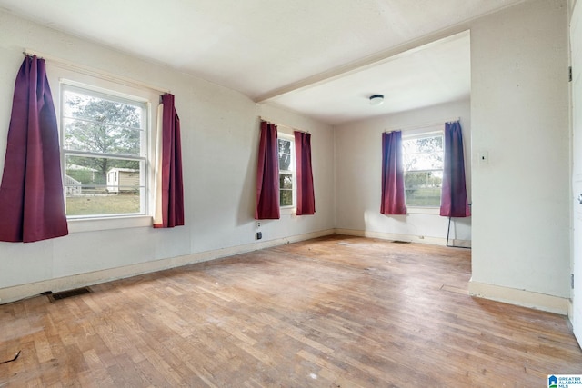 empty room with a healthy amount of sunlight and light hardwood / wood-style floors