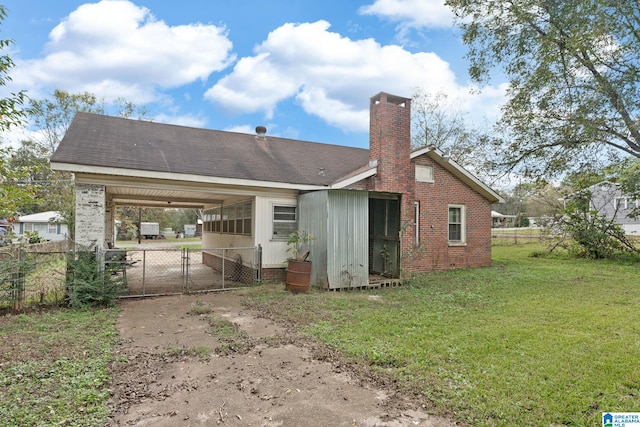 back of property featuring a carport and a yard