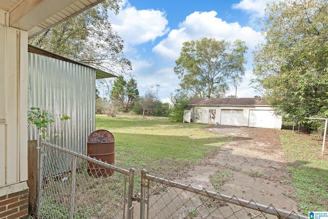 view of yard with a garage and an outbuilding