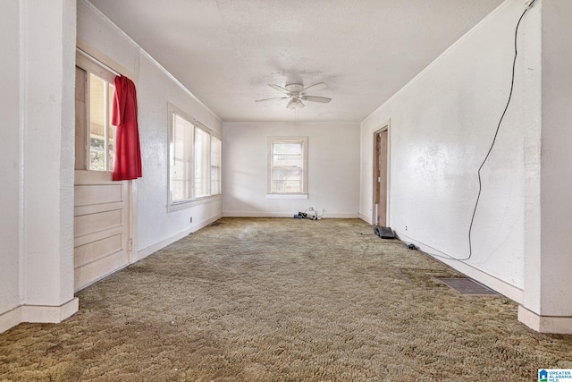 carpeted spare room featuring ceiling fan and a textured ceiling