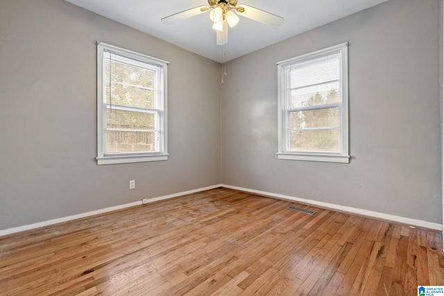 spare room featuring ceiling fan, a healthy amount of sunlight, and light hardwood / wood-style flooring