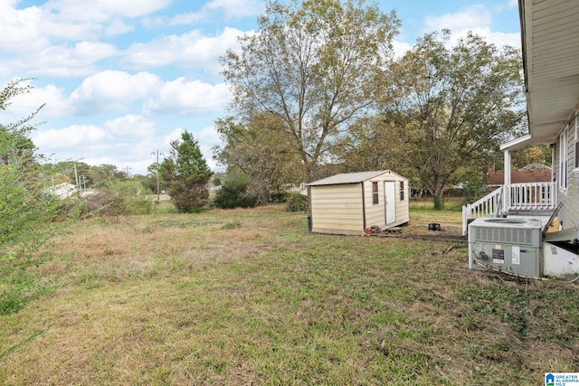 view of yard featuring central AC and a storage unit