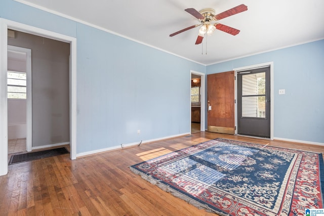 interior space featuring ceiling fan, wood-type flooring, and crown molding