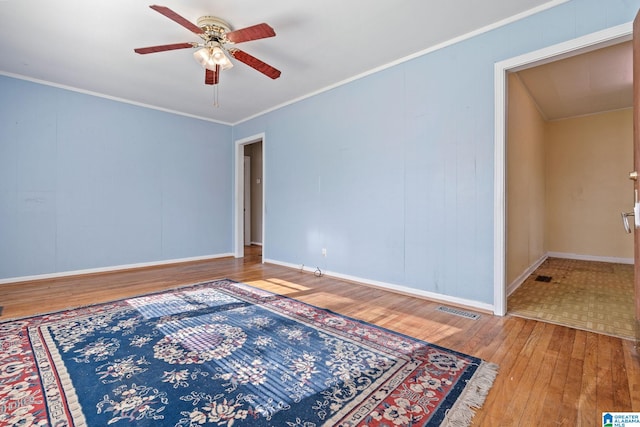 unfurnished room featuring hardwood / wood-style flooring, ceiling fan, and crown molding