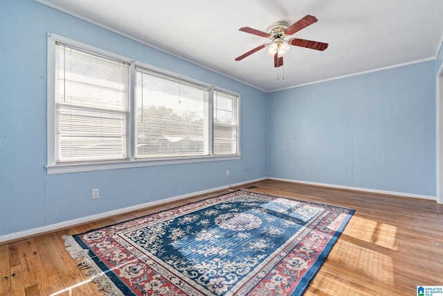 spare room with hardwood / wood-style flooring, ceiling fan, and crown molding