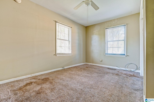 carpeted spare room with ceiling fan