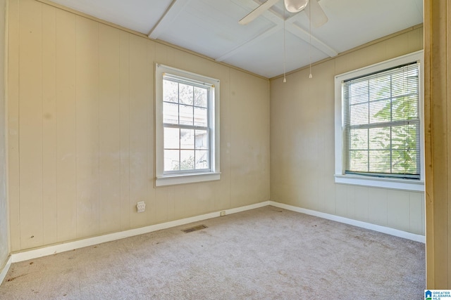 unfurnished room featuring ceiling fan, light carpet, and wooden walls