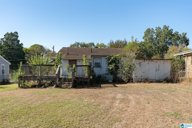 back of house with a lawn and a deck