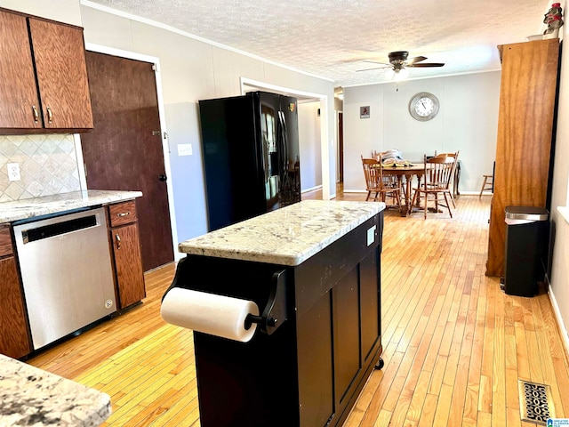 kitchen featuring a center island, light hardwood / wood-style flooring, stainless steel dishwasher, and black refrigerator with ice dispenser