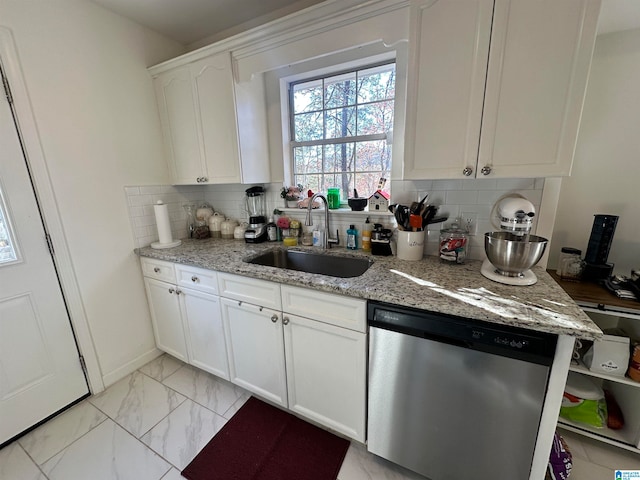 kitchen with dishwasher, tasteful backsplash, white cabinetry, and sink