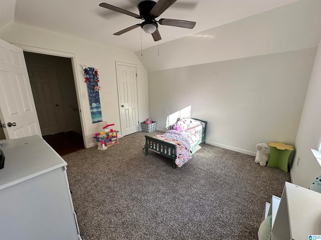 bedroom with ceiling fan, vaulted ceiling, and dark colored carpet