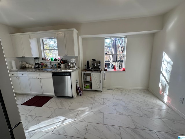 kitchen with white cabinets, light stone counters, tasteful backsplash, sink, and dishwasher