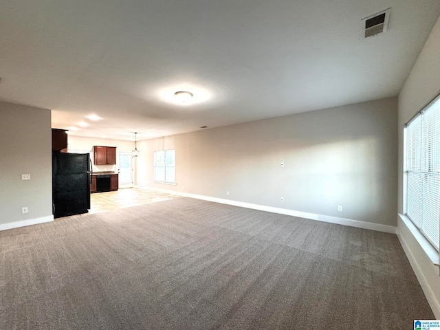 unfurnished living room featuring light colored carpet