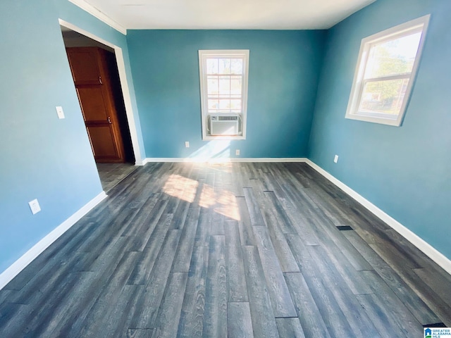 unfurnished room featuring a wealth of natural light, dark hardwood / wood-style flooring, and cooling unit