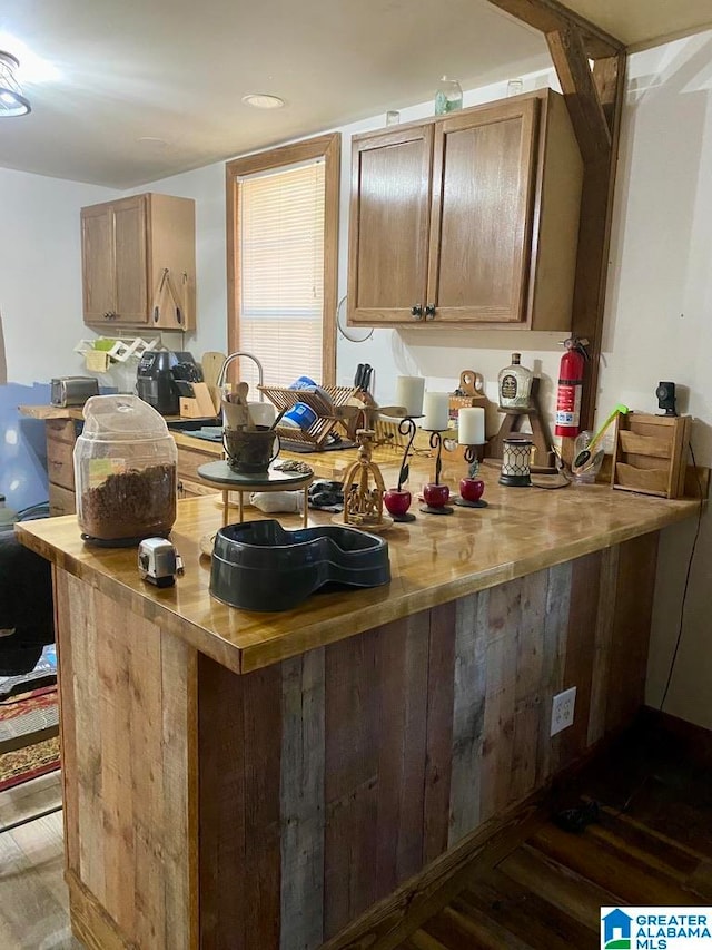 kitchen featuring kitchen peninsula and dark wood-type flooring