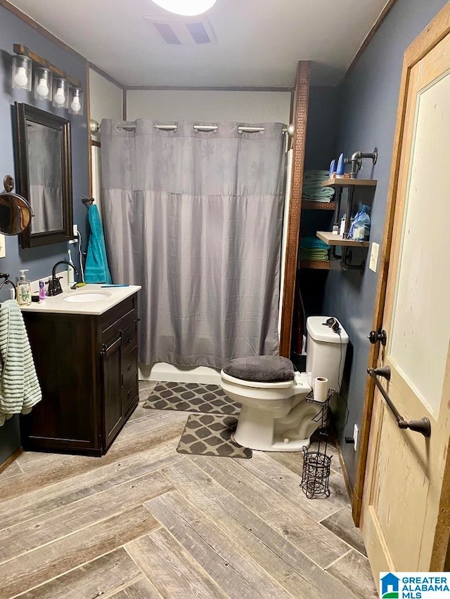 bathroom featuring toilet, vanity, and hardwood / wood-style flooring